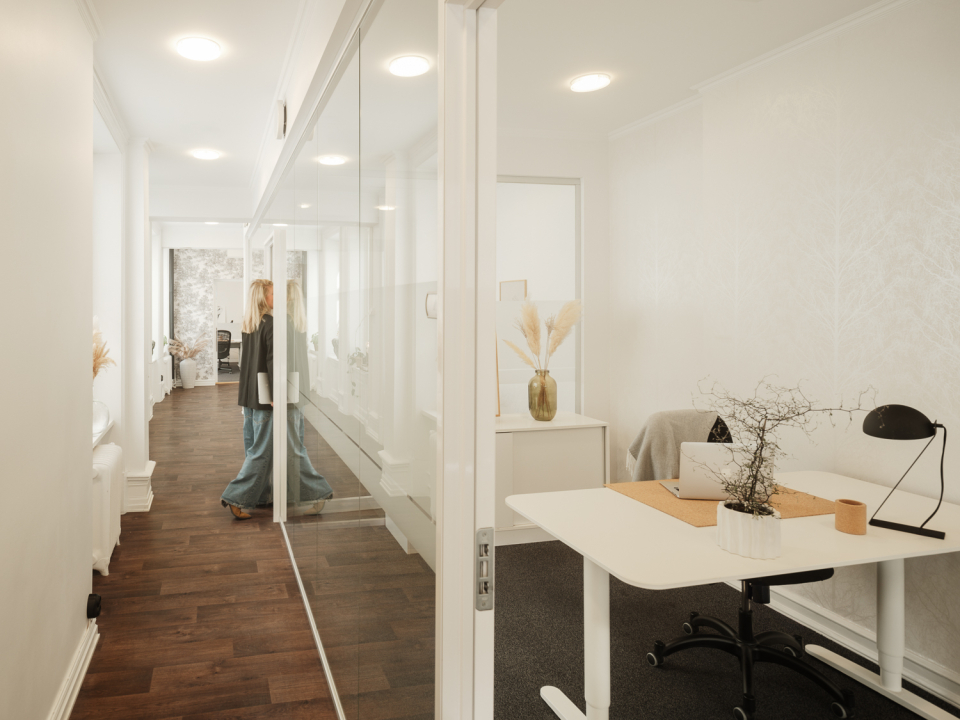 Kontor med glasrutor ligger i en kontorskorridor.